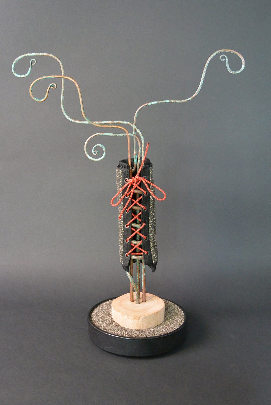 Tami Matozo Research, 2021 - a slender standing figure with curling wire antennae and red lacing at its centre, on a round base.