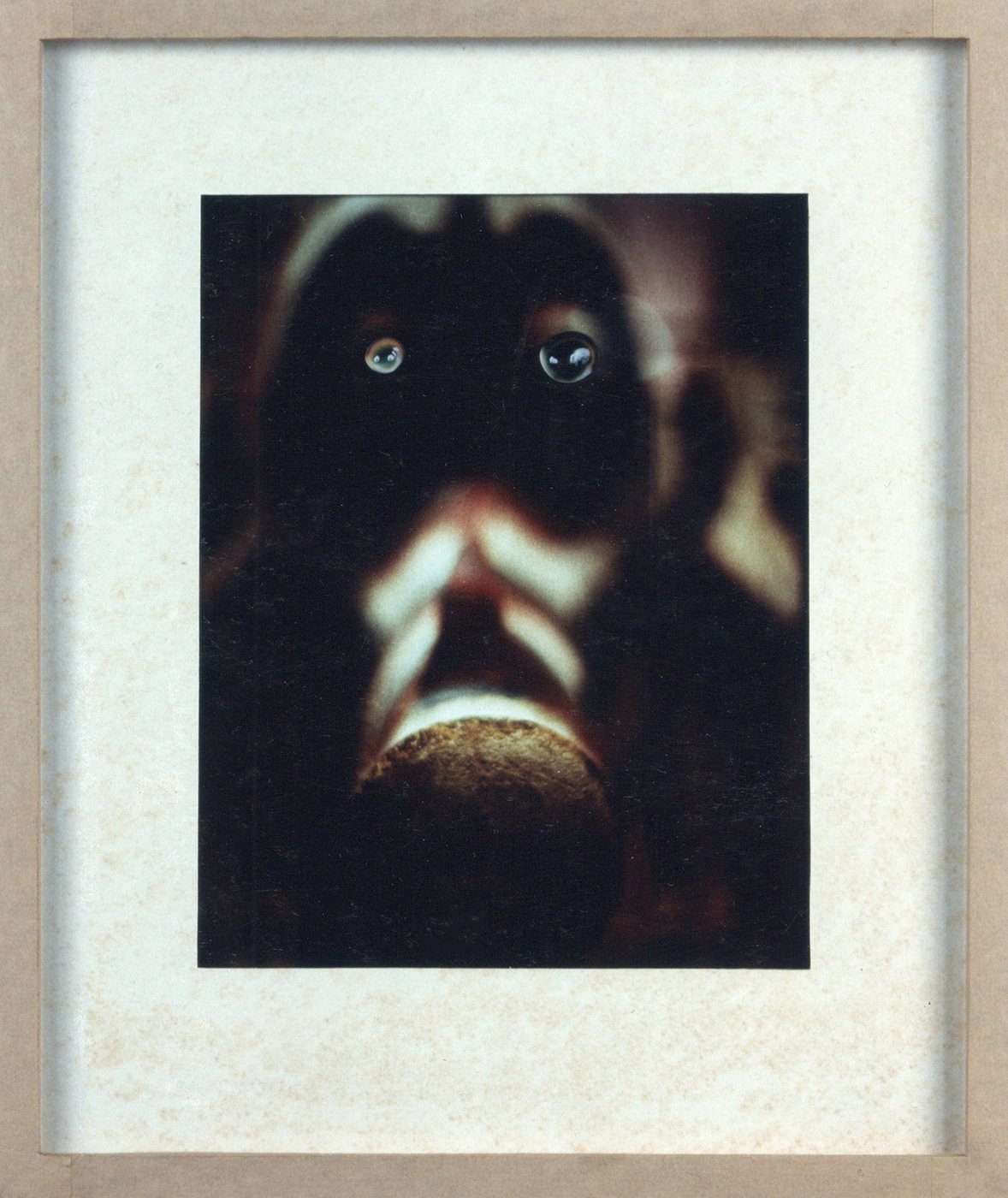 The Ugly, 1993 - a framed dark photograph of a face with the mouth open and a pale rounded form at the chin.